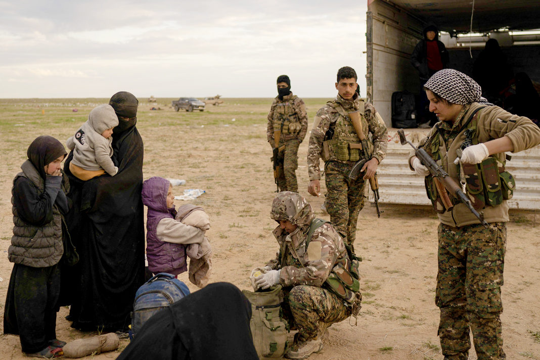 Women and children are screened by U.S.-backed Syrian Democratic Forces