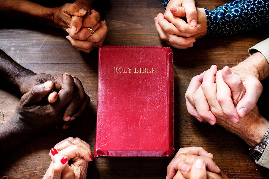 Praying hands with Bible