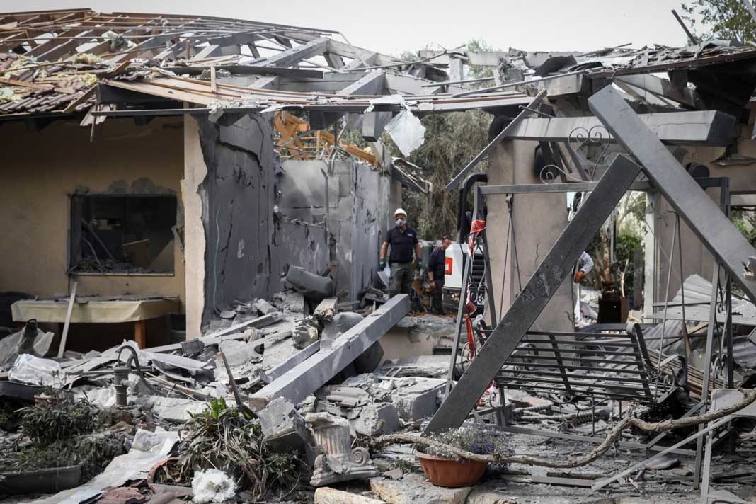 Israeli security forces inspect a house in Moshav Mishmeret, in central Israel, hit by a rocket fired from the Gaza Strip