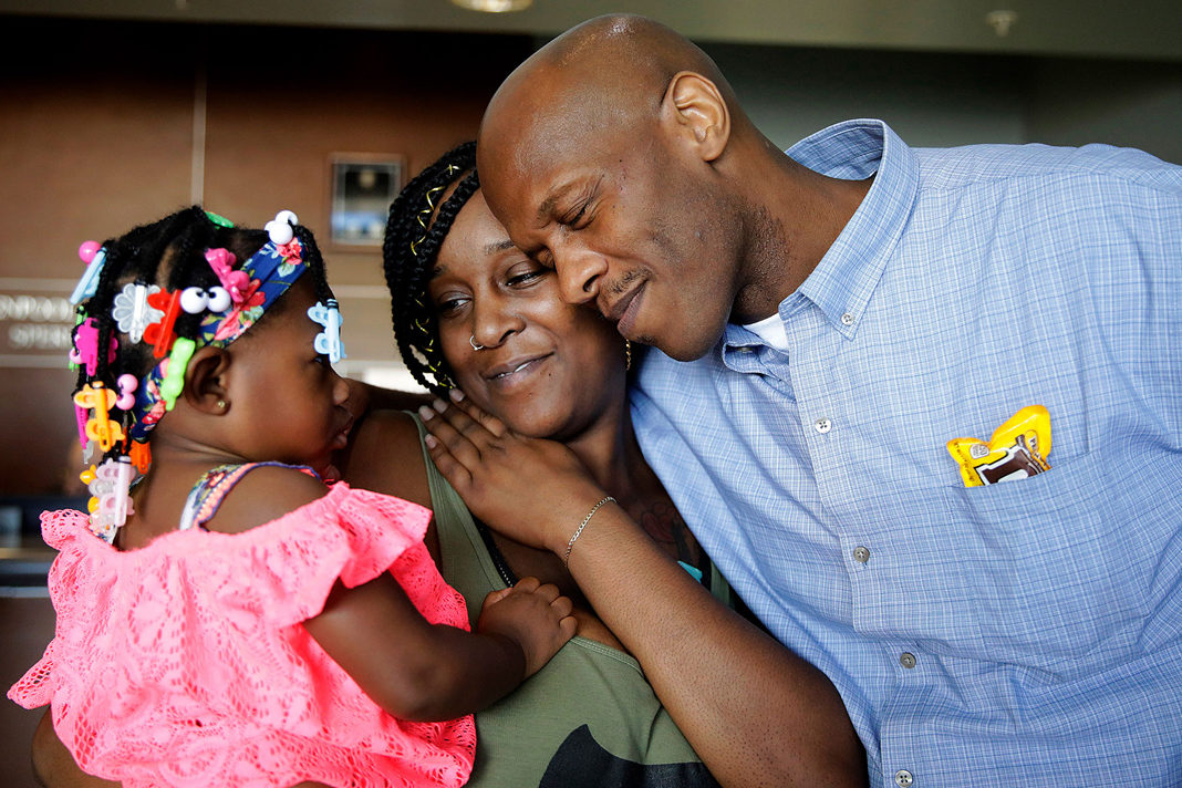 Corey Atchison visits with his daughter Courtney Thomas, center, and his niece Eyght Brown, 2, as he is freed.