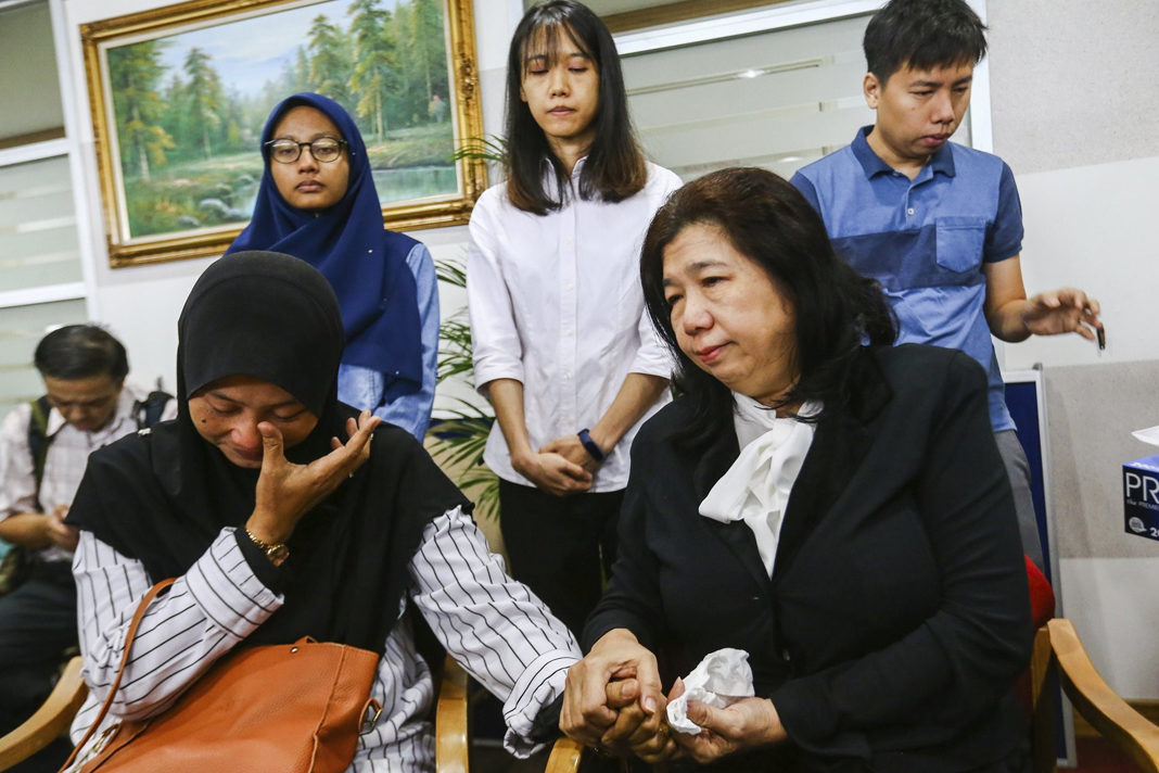 Norhayati Mohd Arifin, sitting at left, wife of Amri Che Mat and Susanna Liew Sow Yoke, sitting at right, wife of Pastor Raymond Koh .Vincent Thian / AP