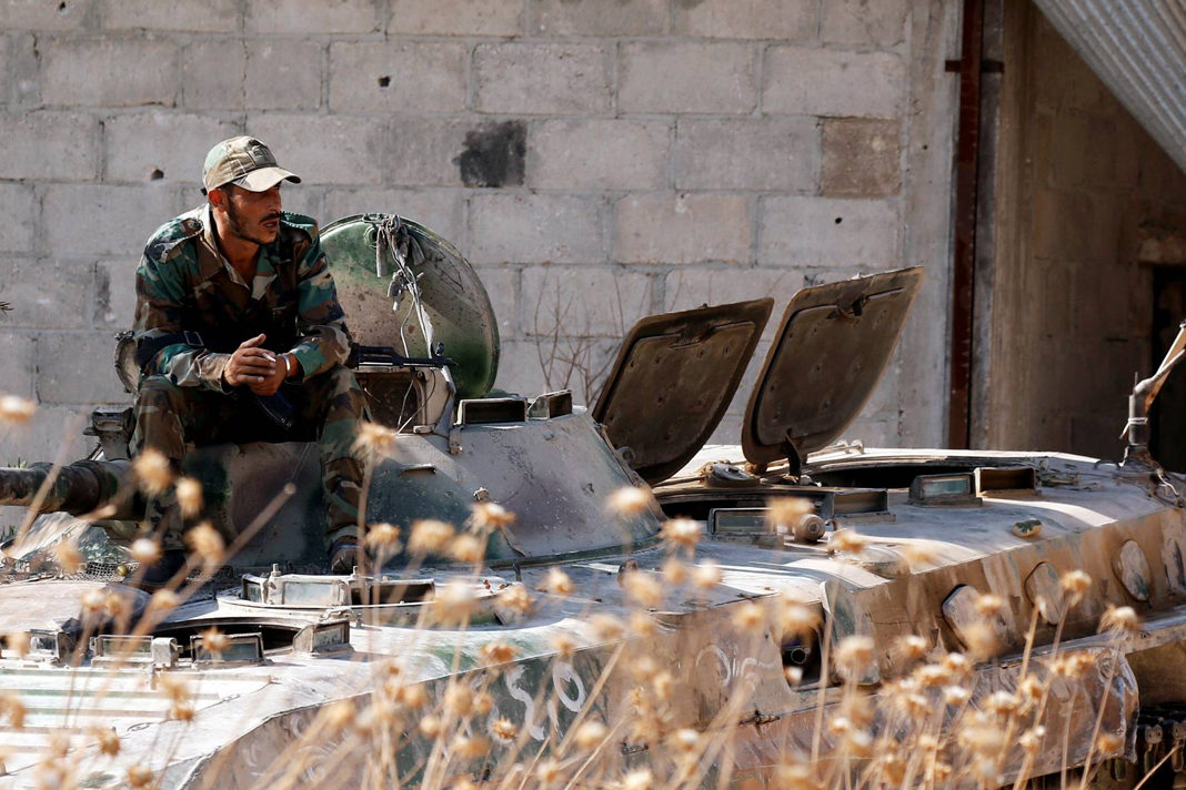 A Syrian army soldier smokes cigarette as he sits on a military vehicle in Khan Sheikhoun, Idlib. © Reuters/Omar Sanadiki 