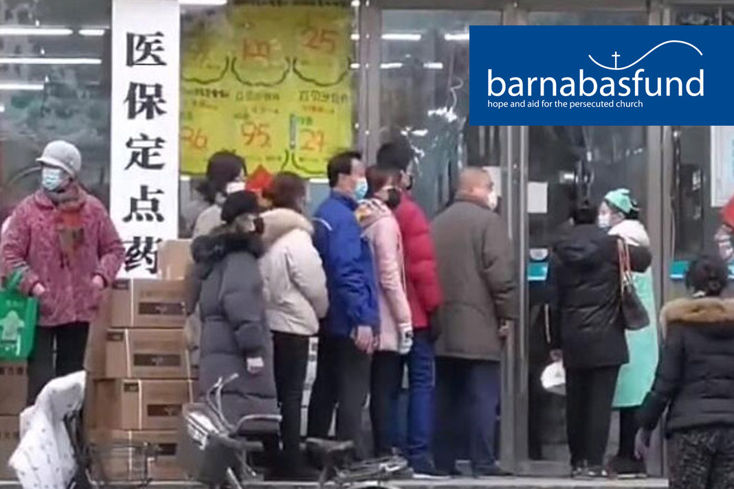 Residents of Wuhan queue up outside a chemist shop in an attempt to buy a filter mask, now so rare they are 