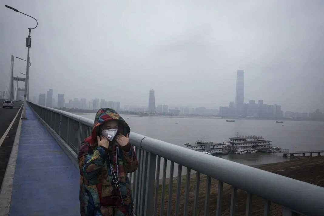believers-in-wuhan-brave-coronavirus-to-share-the-gospel A woman wears a protective mask as she walks across the Yangtze River Bridge in Wuhan, China.