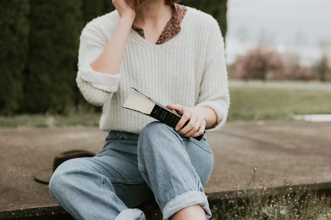 Young person sitting with Bible