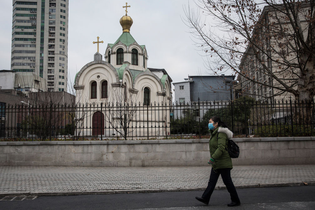 pastor-in-wuhan-government-officials-arent-stopping-us-from-reaching-the-community-anymore women wears a protective mask as she past the church on February 8, 2020, in Wuhan, Hubei province, China.