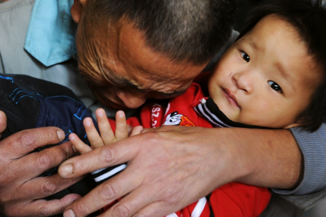 china-threatens-to-forcibly-take-children-from-christian-families-to-re-education-camps A father weeps as he hugs his son, one of 60 who were rescued from child traffickers. Credit: Stringer